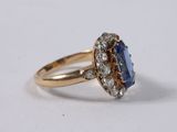 a close up of a gold ring with a sapphire and diamonds