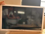 a man standing next to a bed with a television on it