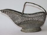 une image représentant un panier en métal muni d'une poignée, posé sur une surface blanche