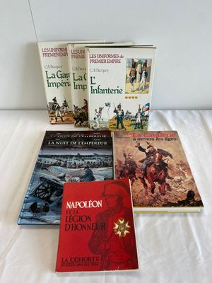 four books are sitting on a bed with a white sheet