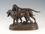 bronze statue of two dogs on a leash on a wooden base