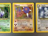 trois cartes Pokémon posées les unes à côté des autres sur une table