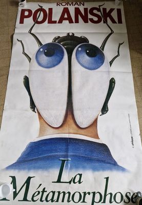 poster on the floor of a restaurant with a poster of a man ' s face with large blue eyes