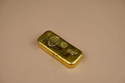 a gold bar sitting on a white surface