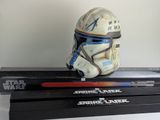 un casque de Star Wars posé au sommet d'une pile de livres Star Wars