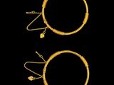 a pair of gold hoop earrings and a pair of gold hoop earrings