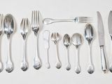 un grand nombre de cuillères et de fourchettes en argent disposées sur une table