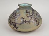 a vase with a bird design on it on a white surface