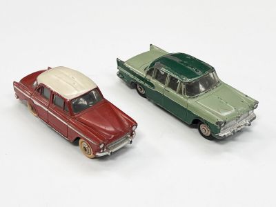deux voitures jouets assises l'une à côté de l'autre sur une surface blanche