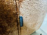 a close up of a brown pillow with a blue label on it
