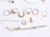 a lot of gold jewelry on a white surface