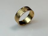 a close up of a gold ring on a white surface