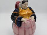 une figurine représentant un homme assis sur un tonneau