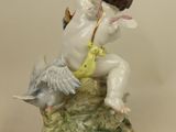 a figurine of a cupid with a bird on it