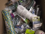 une boîte en carton remplie de pelotes de laine de toutes sortes et d'autres objets