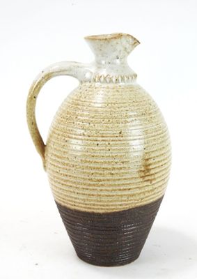a brown and white vase with a handle on a white background