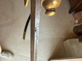 someone is holding a sword in their hand in a living room
