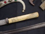 a knife, a hammer, and other items on a table