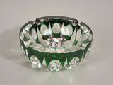 un cendrier en verre vert posé sur une table blanche