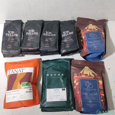 several bags of coffee sit on a table next to a bag of tea