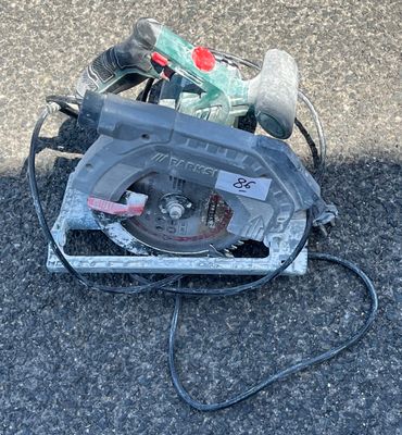 une scie circulaire posée par terre à côté d'une paire de chaussures