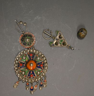 three pieces of jewelry are displayed on a gray surface