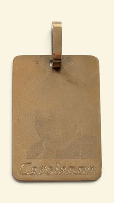 an image of a gold luggage tag with a name on it