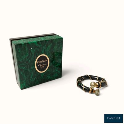 un gros plan sur un bracelet et un coffret posés sur une surface blanche