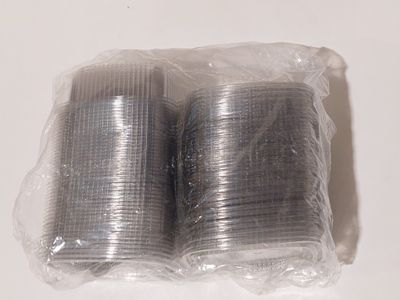 deux rouleaux de fil d'argent emballés dans du plastique sur une surface blanche