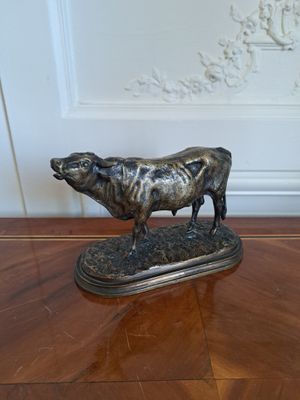 une statue représentant une vache debout sur une table en bois