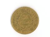 a gold coin on a white surface with a white background