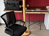 une chaise de bureau noire posée devant un mur rouge