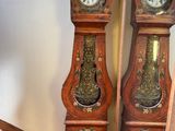 deux horloges de parquet placées l'une à côté de l'autre dans l'escalier