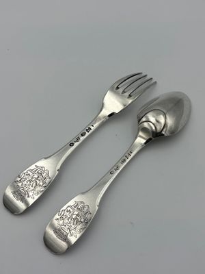 pair of silver plated spoons and a fork on a white surface
