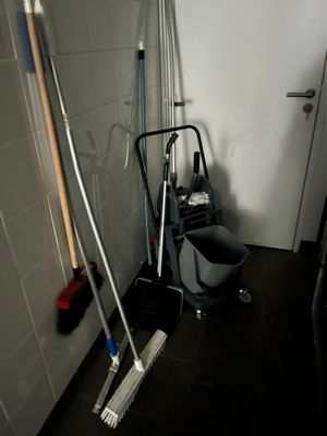 une serpillière, un seau et un balai dans une petite pièce