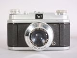 a black and silver camera on a white surface