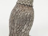 a silver owl figurine sitting on top of a white surface