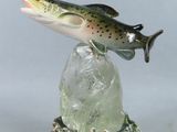 statue représentant un poisson assis sur un rocher, à côté d'une ficelle