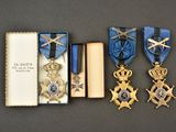 three medals and a book sit on a table next to each other