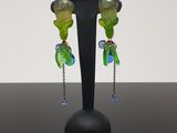 boucles d'oreilles composées de perles de verre vertes et bleues et de chaînes, montées sur un support noir