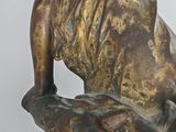 bronze statue of a lion on a rock with a bird perched on it ' s head