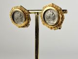a close up of a pair of gold and silver roman coin earrings