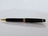 a black pen sitting on top of a table next to a white surface