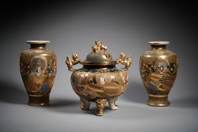 three vases with designs on them sitting on a gray surface