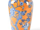an orange vase with blue and white designs on it