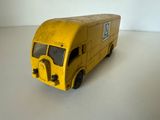 un petit camion jaune en plastique posé sur une table