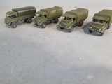 several toy army trucks are lined up in a row on a table