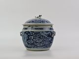 un vase bleu et blanc muni d'un couvercle, posé sur une surface blanche