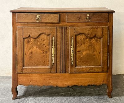 une armoire en bois dont les portes et les tiroirs sont sculptés