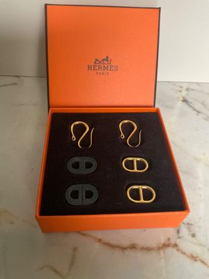 an orange box containing three pairs of earrings and a pair of scissors
